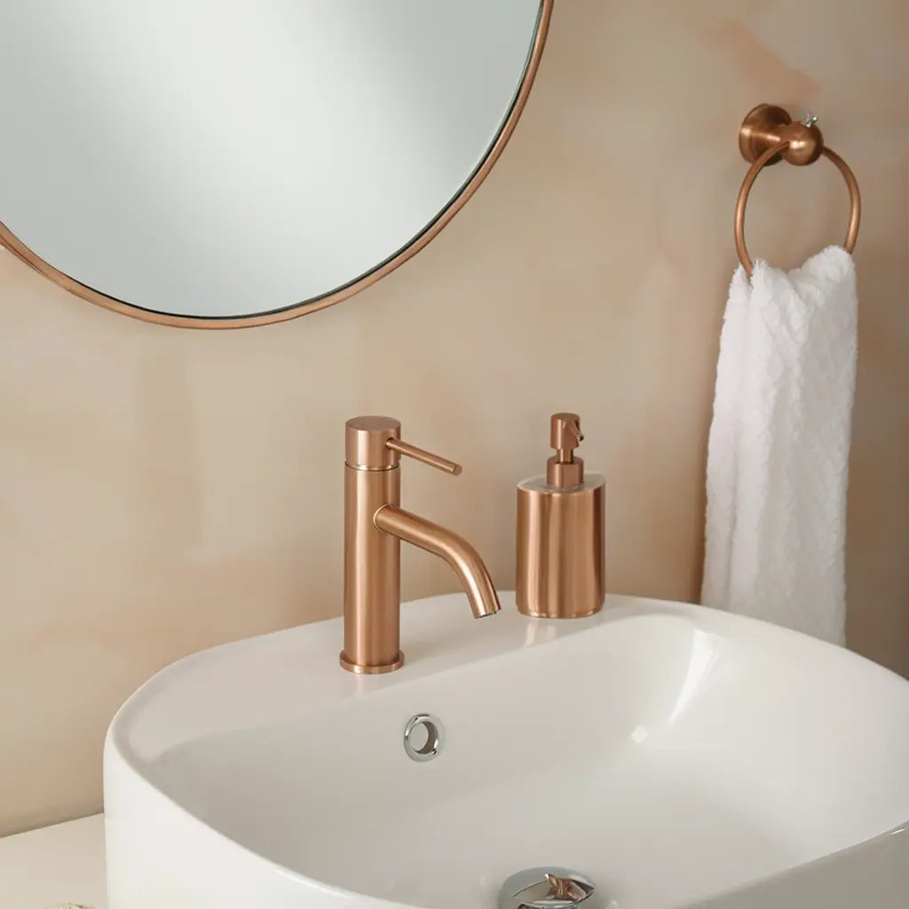 Mitigeur lavabo or rose brossé en laiton dans une salle de bain