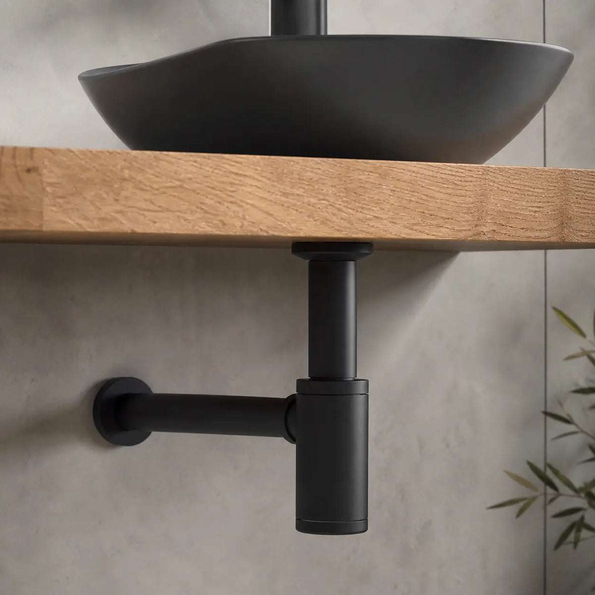 Siphon lavabo noir mat fixé dans une vasque noir à travers un meuble bois