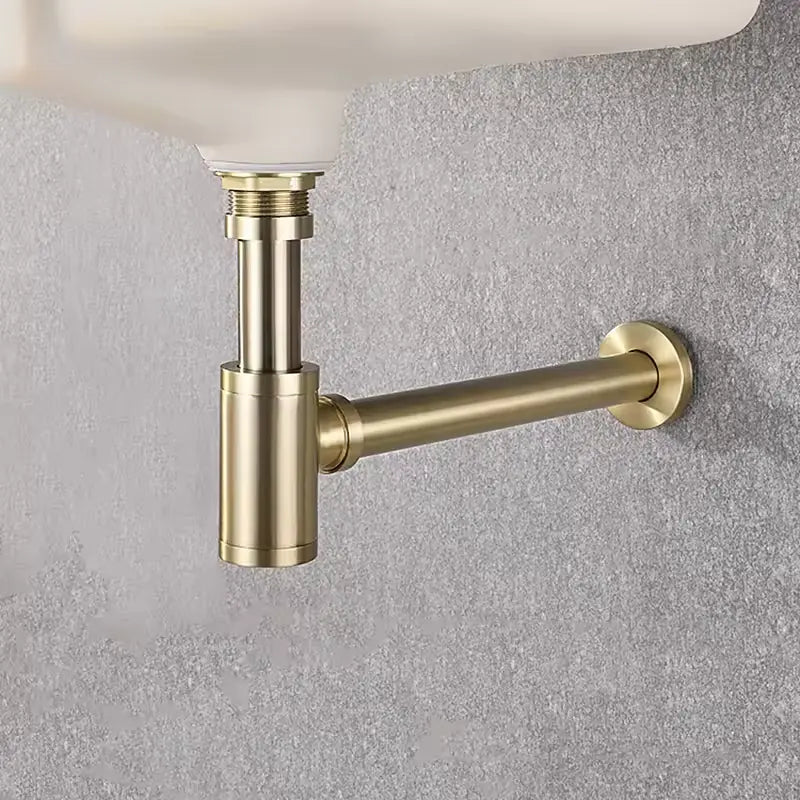 Siphon lavabo or brossé fixé dans une vasque blanche